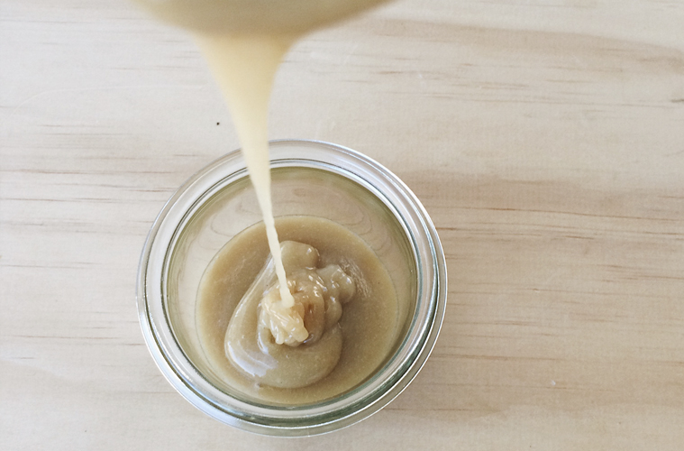 Healthy Caramel Sauce being poured into a glass jar