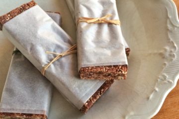 Raw Breakfast Bars wrapped in paper on a white plate