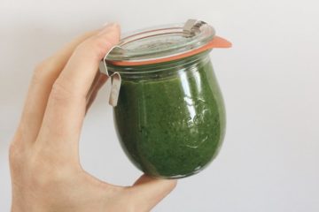 Basil Parsley and Cashew Pesto in a weck jar held up by a hand