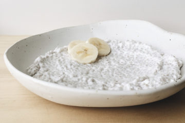 Coconut Chia Pudding in a white shallow bowl with three slices banana.