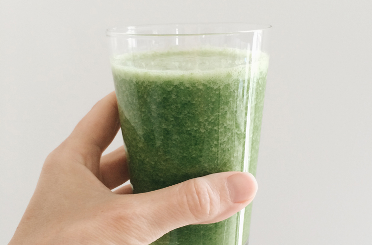 Everyday Kale Smoothie in a glass held up by a hand