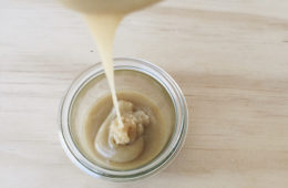 Healthy Caramel Sauce being poured into a glass jar