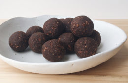 Leftover nutmilk balls in a white bowl on a wooden surface