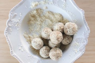 raw lemon truffles rolled in coconut on a white plate