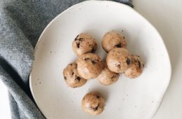Raw Choc Chip Bites on a white plate with a grey napkin