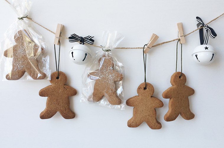Ginger Bread Men Advent calendar hanging of a string pinned with pegs, with two white bells attached to the string for decoration
