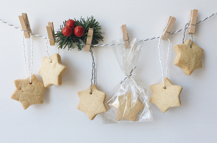 Shortbread stars advent calendar, hanging off a white and grey string, pinned with mini pegs and a green and red christmas decoration