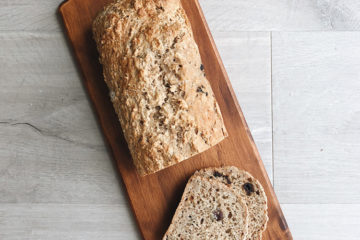 Easy oat and hazelnut loaf on a wooden board with two slices cut off