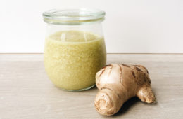 Ginger Handscrub in a Weck jar with a piece of ginger next to it on a wooden surface