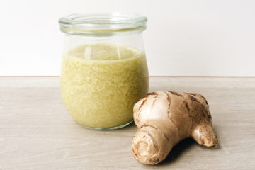 Ginger Handscrub in a Weck jar with a piece of ginger next to it on a wooden surface