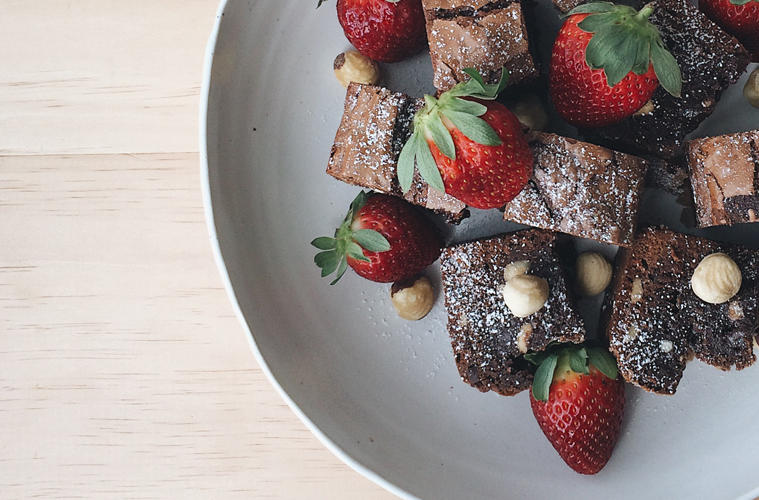 Nutella Brownies with strawberries and hazelnuts on a white plate