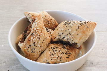Pork and Fennel Sausage Rolls in a white bowl on a wooden surface
