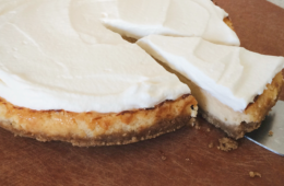 Key Lime Pie on a wooden board with a slice on a cake server