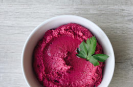 Beetroot Hummus in a white bowl on a wooden surface