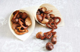 spiced glazed nuts tumbling out of two cones onto a linen sheet