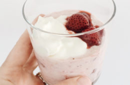 Overnight Strawberry Oats in a glass held by a hand