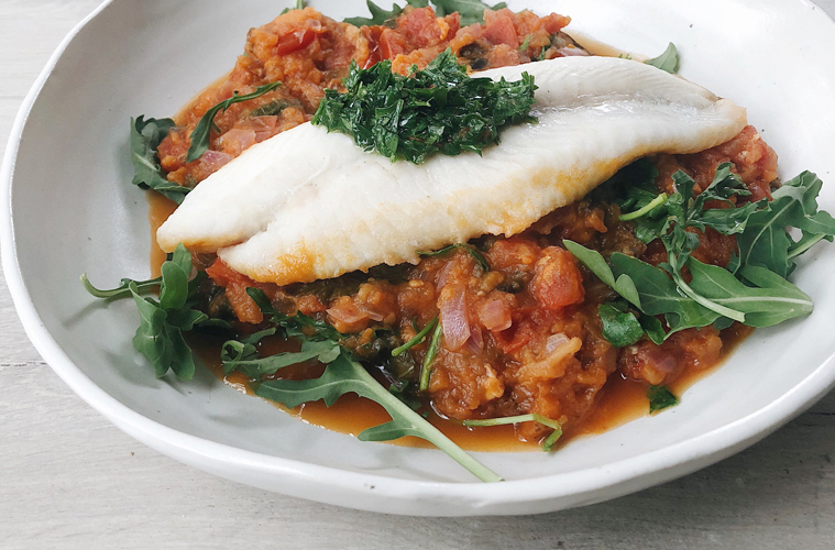 Argentine style fish with caponata on a white plate
