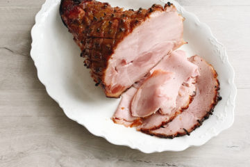 christmas glazed ham on a white serving plate