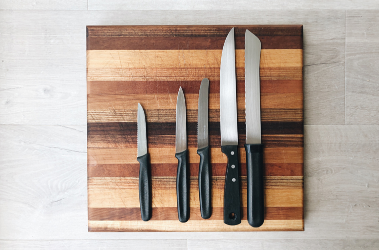5 knives on a wooden board