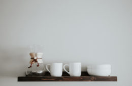 coffee maker and coffee cups on a shelf