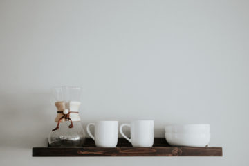 coffee maker and coffee cups on a shelf