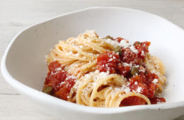 spaghetti with tomato and caper sauce in a white boal