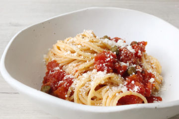 spaghetti with tomato and caper sauce in a white boal