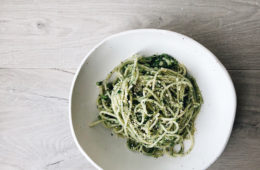 spaghetti with zucchini and spinach on a white plate