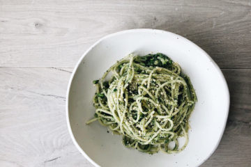 spaghetti with zucchini and spinach on a white plate