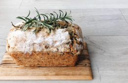 olive oil, dark chocolate and rosemary cake on a wooden board