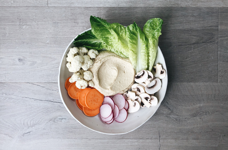 dip bowl overhead with hummus and vegetables