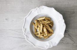 almond tomato and garlic pesto with penne on a white plate